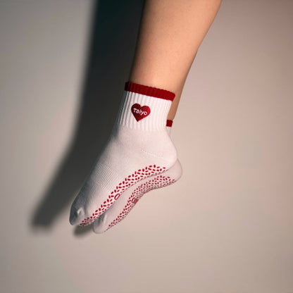 גרבי פילאטיס לנשים דגם HeartU בצבע לבן עם לב אדום, סוליה מונעת החלקה, מתאימות לפילאטיס ויוגה.